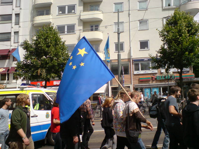 En demonstrant bör på en Kina-flagga i EU:s färger, i protest mot EU:s massövervakning.